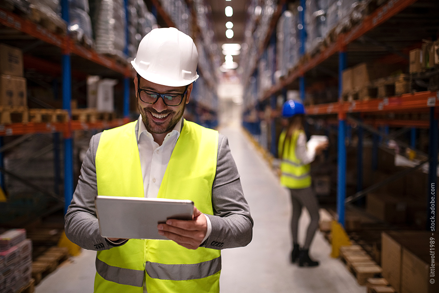 man smiling using tablet at warehouse
